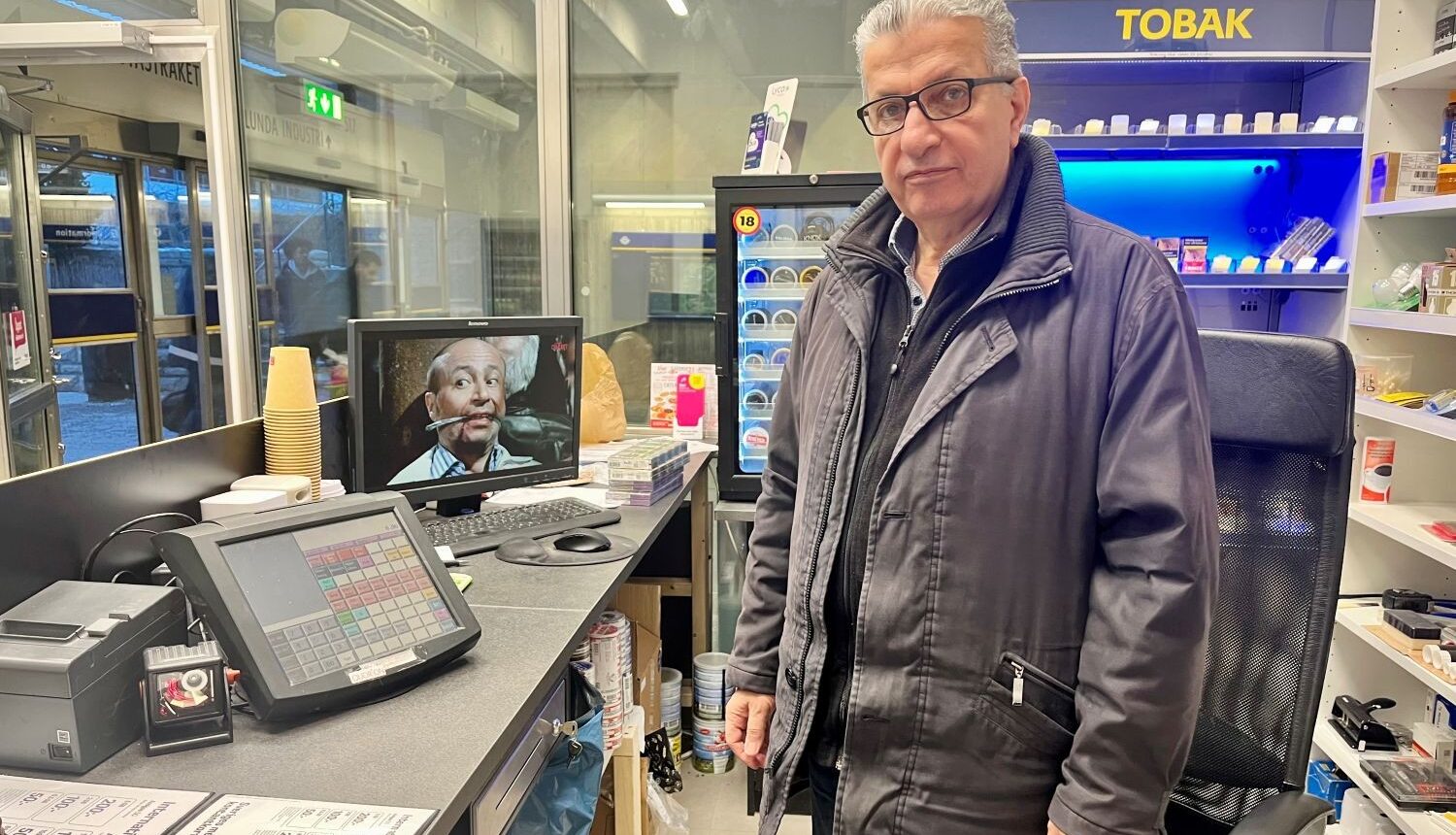 man stå bakom kassan i en kiosk