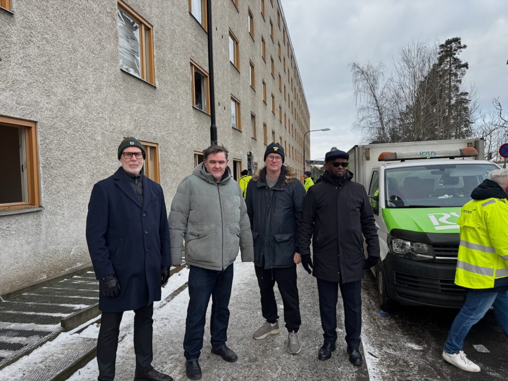 Fyra män utanför fastigheten där porten sprängdes.