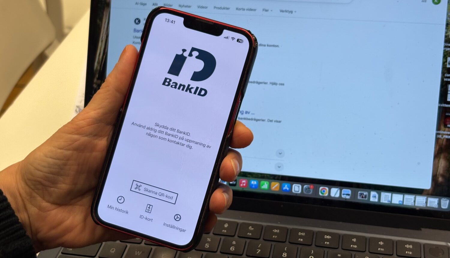 En hand som håller i en mobil med bank-id-appen uppe.
