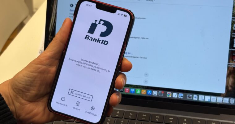 En hand som håller i en mobil med bank-id-appen uppe.