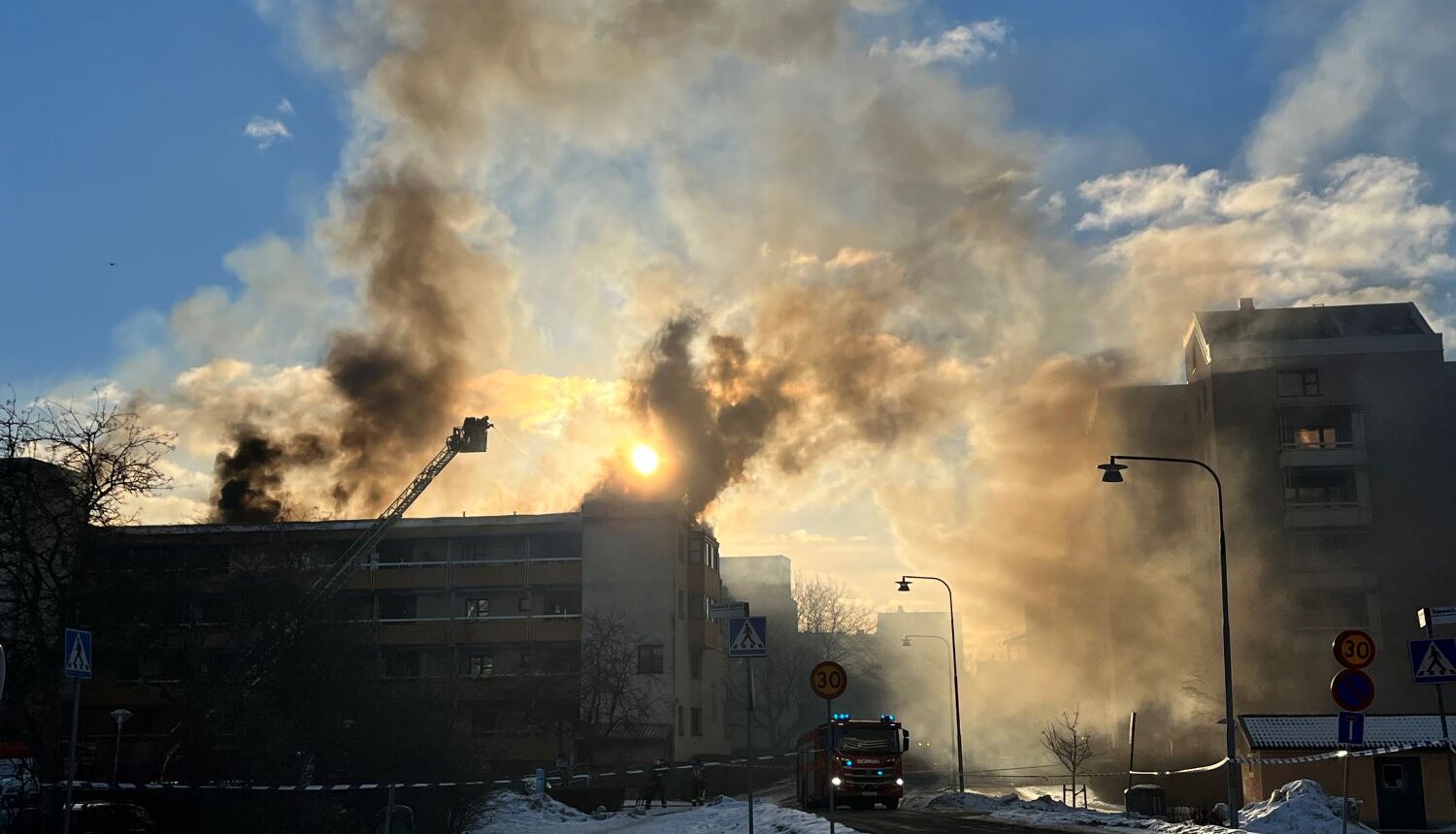 rök stiger i motljus från brand i ett flerfamiljshus