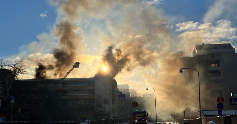 rök stiger i motljus från brand i ett flerfamiljshus