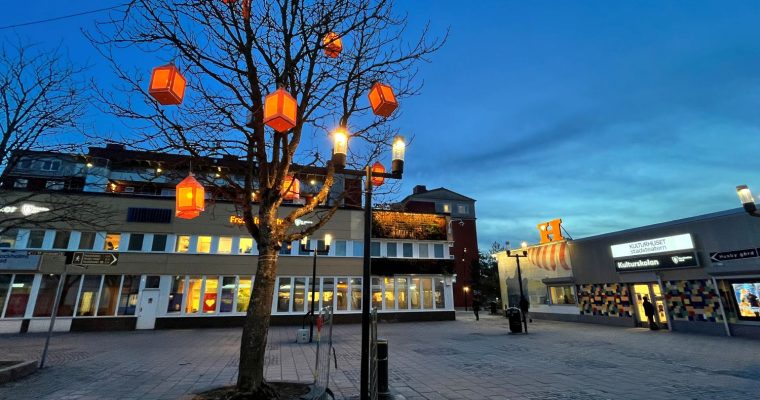 eidpynt i form av lyktor hänger i träden på Husby torg