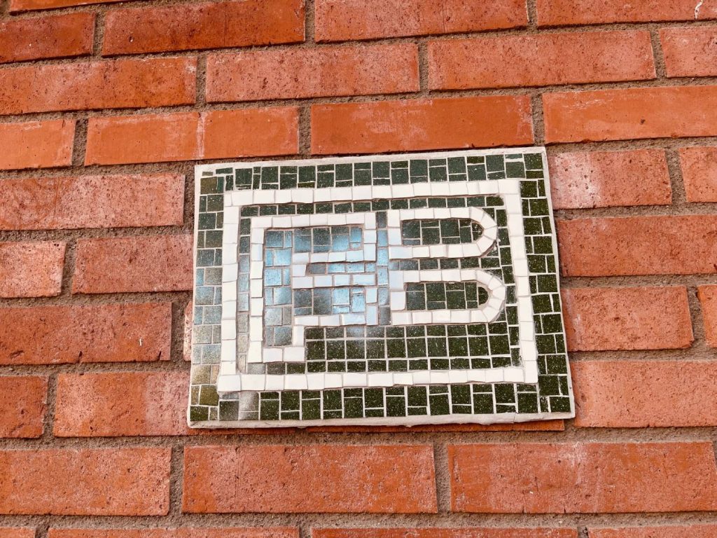 Familjebostäders skylt i mosaik på Hinderstorpsgränd.