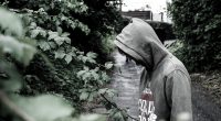 En svartvit bild ppå kille i hoodie.