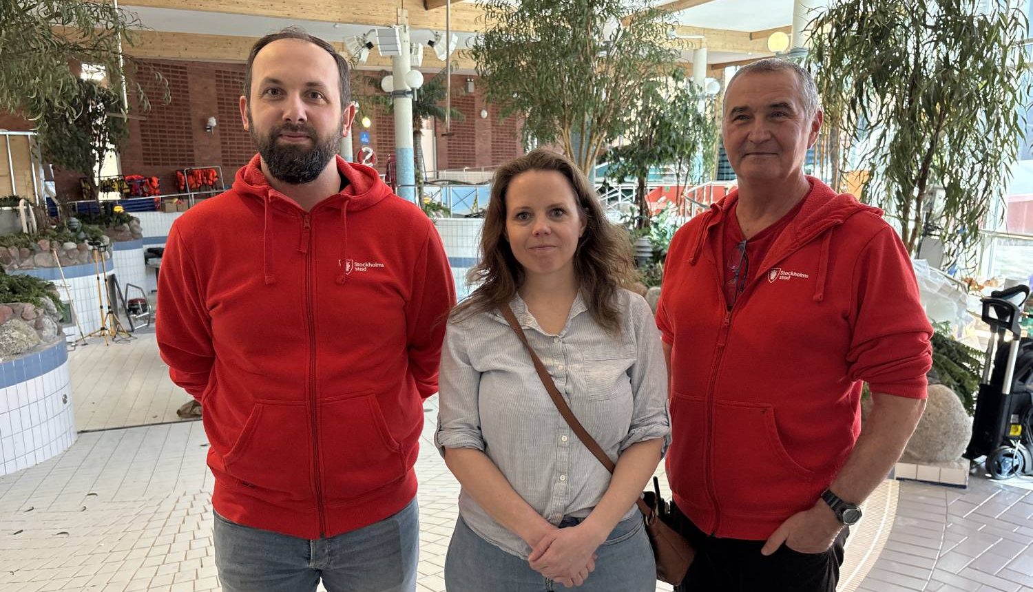 två män och en kvinna i mitten framför ett stängt äventyrsbad