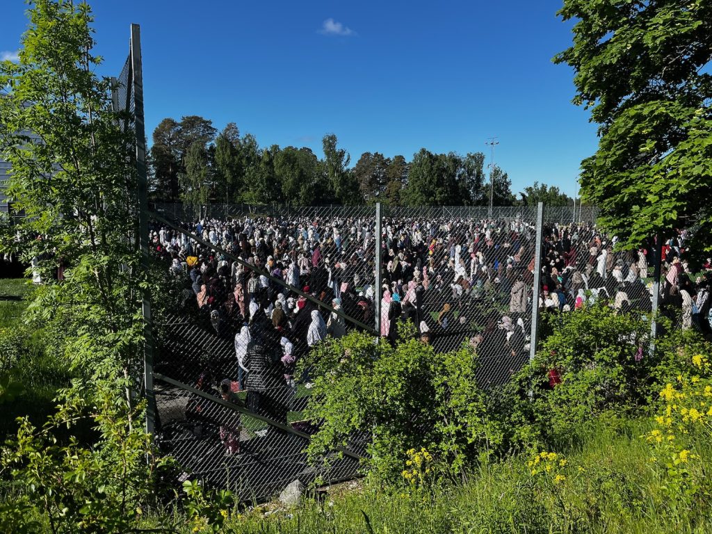 Rinkeby bollplan är full med folk som ber.