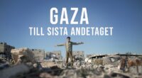 En ung pojke står med armarna utsträckta blandd ruinerna i Gaza.