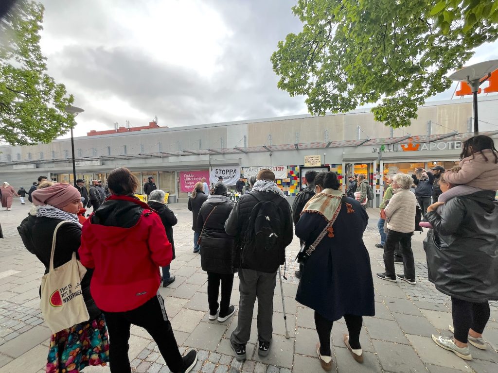 Folksamling på möte i Husby centrum.
