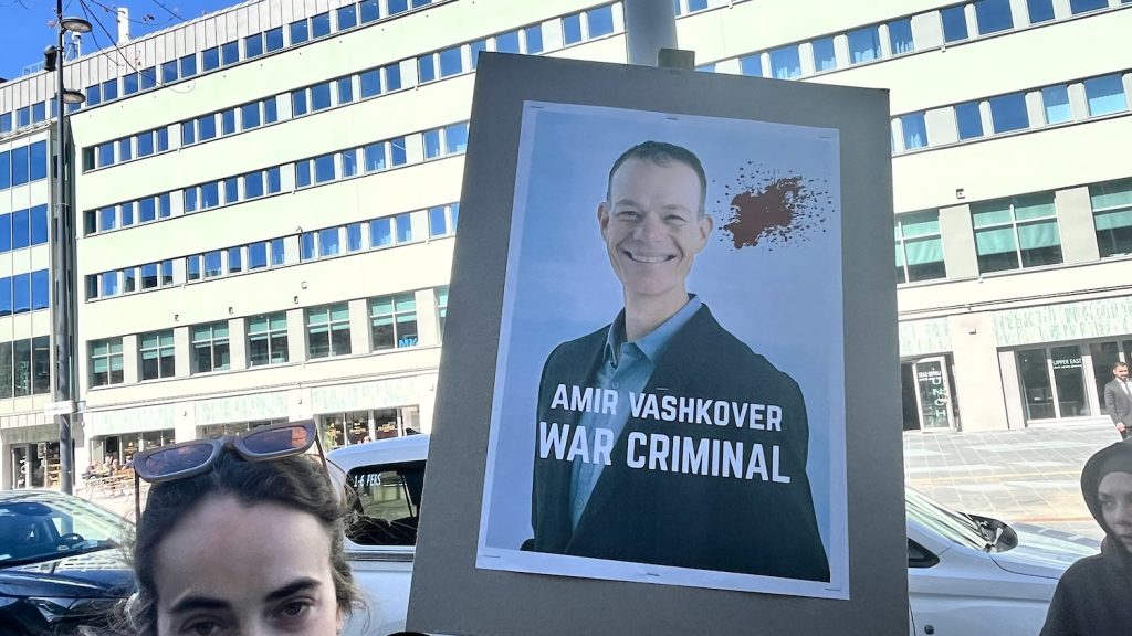Plakat med bild på en leende Amir Vashkover.