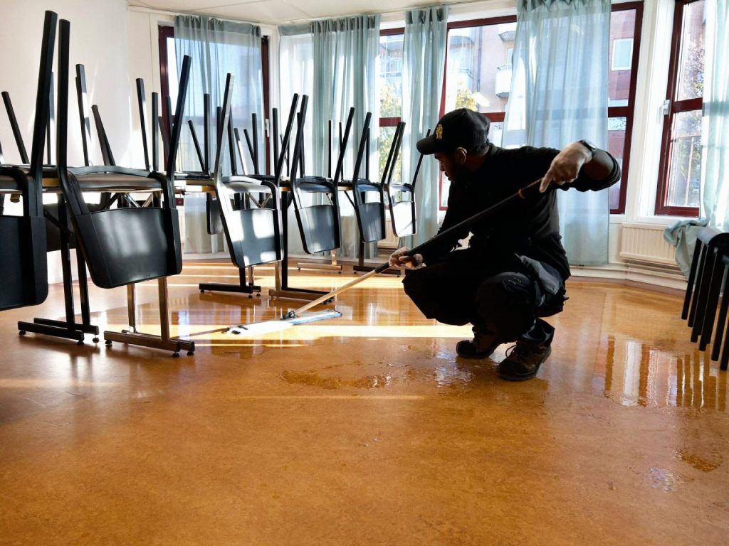 Hussein Hassan Nor städar mötesrummet med god ergonomi.