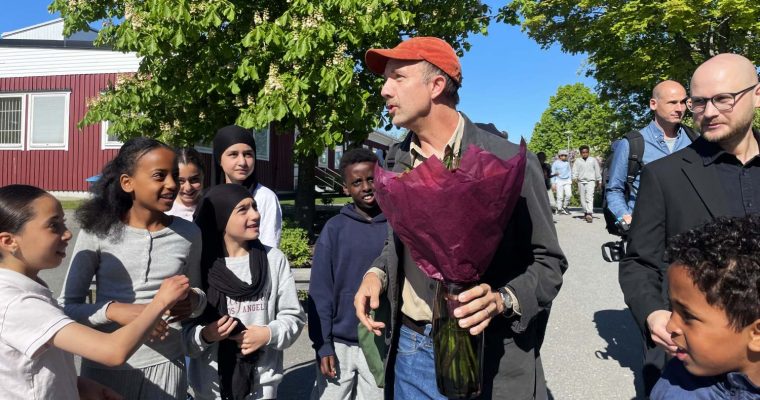 Jon Klassen omgiven av barn från Hjulsta grundskola.