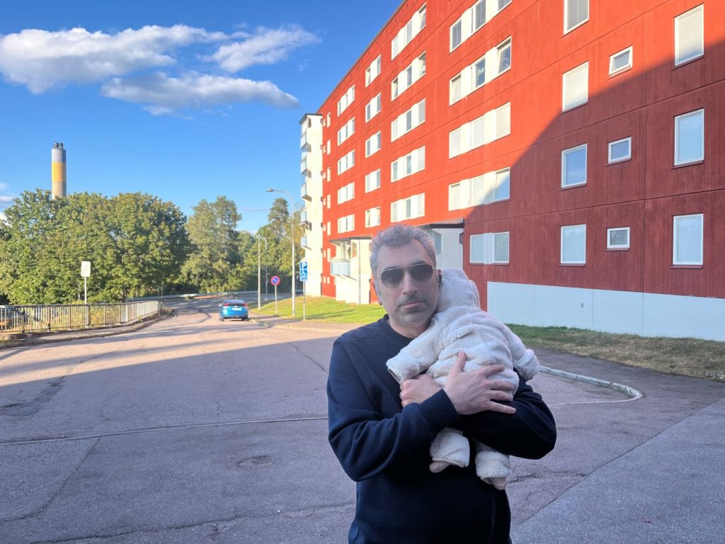 en pappa håller sitt barn på axeln framför en vy med höghus