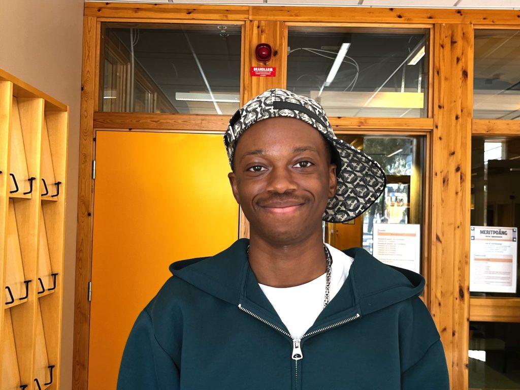 Ung kille med keps, som har sina rötter i Uganda.