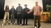 Fem personer på scenen i Rinkeby Folkets Hus. Fyra skådisar i fimen Flaggan och regissören,