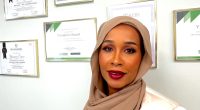 Yasmiin Omar fram väggen med diplom.