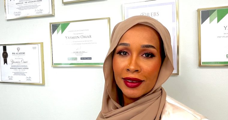 Yasmiin Omar fram väggen med diplom.