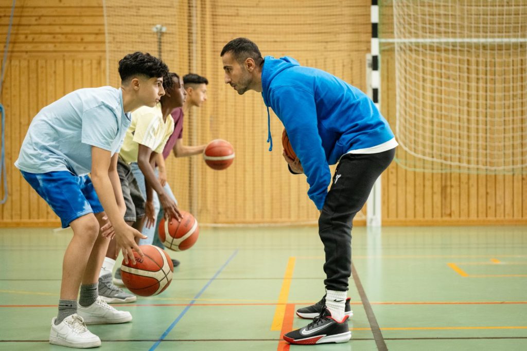 Peshang Rad som Nic med ungdomarna på basketträning.