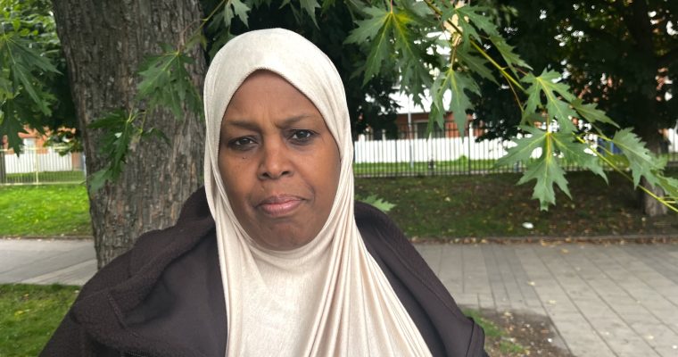 En kvinna i hijab som ser bister ut och tittar rakt in i kameran.