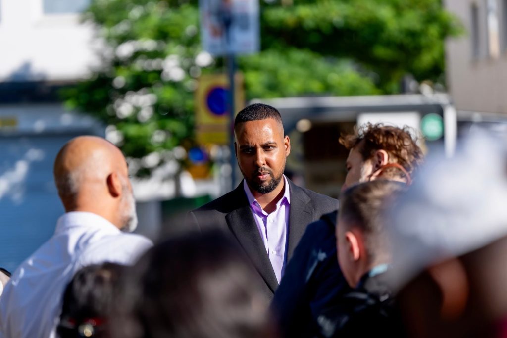 Ilyas i samspråk med män på Rinkeby torg.
