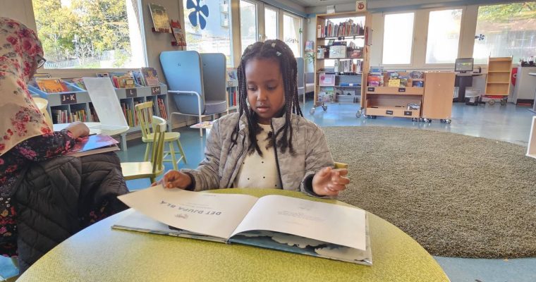 ett barn läser på Rinkeby bibliotek
